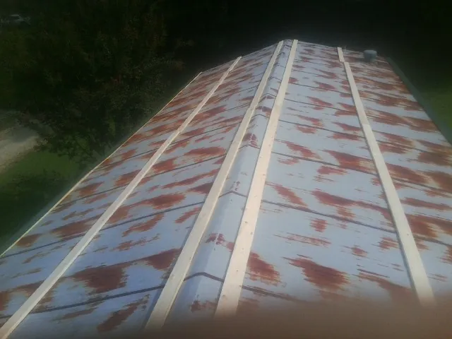 Rusted metal roof panels with new wood purlins before replacement — Storm Damage Roof Repair in Silverlake by Roofing Brothers