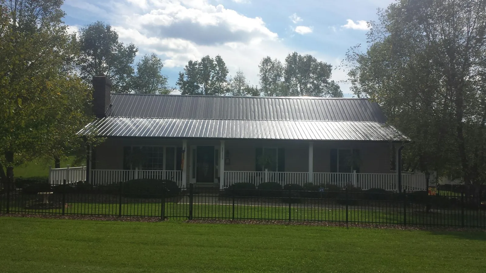 Gray metal roof on a brick ranch with a full width front porch — Gutter Guard Installation work by our crew in Silverlake